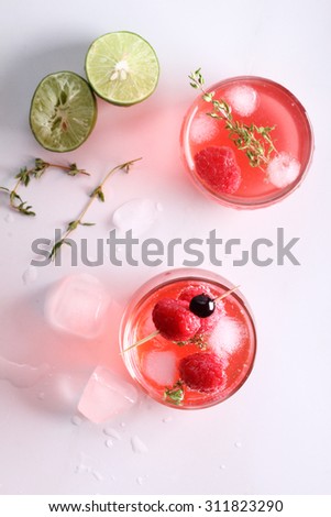 raspberry cocktail in a glass with fresh berry and thyme, top view