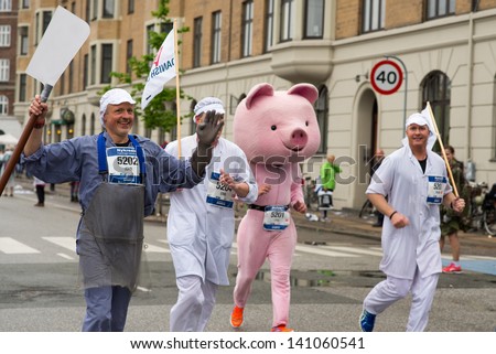 COPENHAGEN -MAY 19: Happy unidentified runners from the Danish Crown company nearing the finish line while cheering at Copenhagen Marathon on May 19, 2013 in Copenhagen.