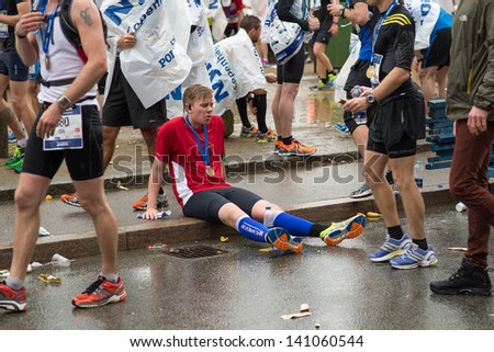 COPENHAGEN -MAY 19: Unidentified man resting his legs after just crossing the finish line at Copenhagen Marathon on May 19, 2013 in Copenhagen.