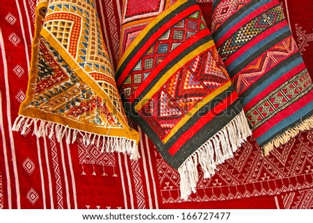 Pile of north african rugs in red, orange & brown shades, Morocco.