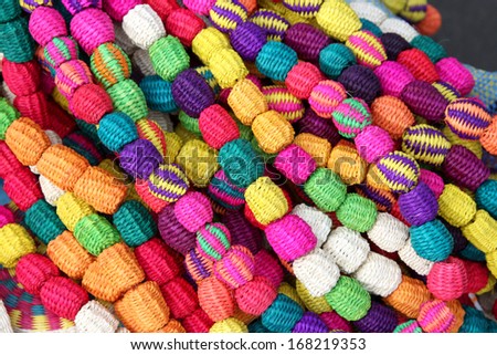 Hand made brightly coloured necklace made with woven straw, South America.