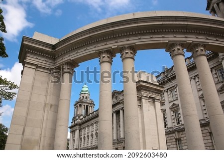 Belfast City Hall building with a classical Renaissance stone exterior and corner tower with columns.  Semi circular monument with columns. Located in Donegall Square, Belfast, Northern Ireland.  