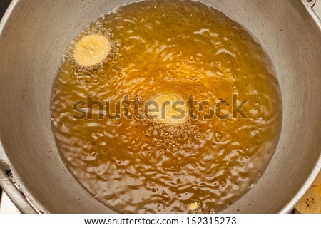 Coconut oil.close up of a frying pan with boiling oil. oil and water. Traditional Banana chips for Onam from Kerala India cuisine.