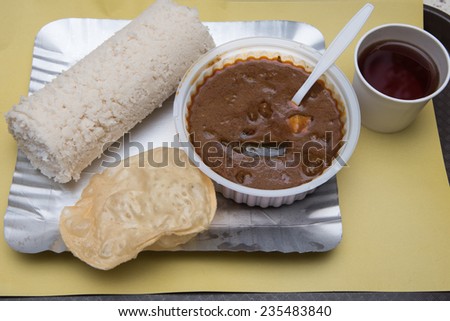 Steamed rice cake with beef curry Kerala India breakfast. steamed rice puttu with spicy meat dish