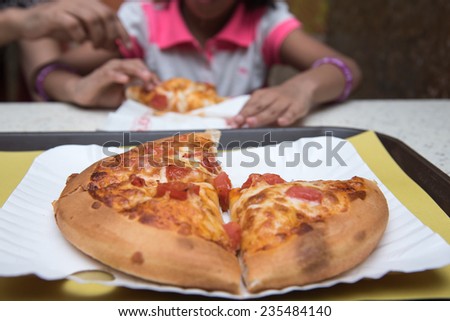 Fresh pizza with tomato and melted cheese. Girl enjoying eating pizza