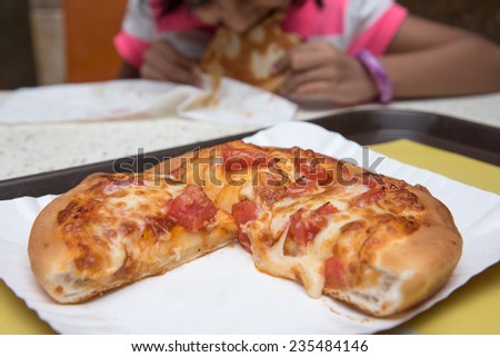 Fresh pizza with tomato and melted cheese. Girl enjoying eating pizza