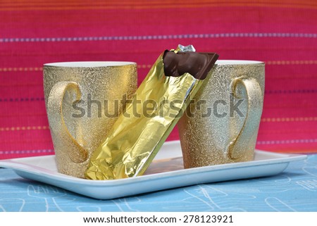 Coffee or tea mugs in a tray. Cup filled with juice or water ready to drink and chocolate for snacks. tableware