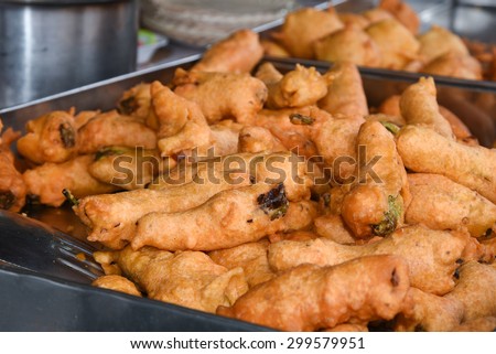 Street food Kerala India, Deep fried crispy snack Chilli bajji, a common snack in south India, served with red hot coconut chutney displayed in a local street shop