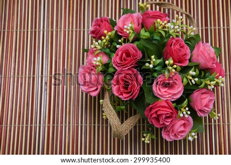 flower vase with beautiful red flowers. artificial flowers isolated on bamboo background