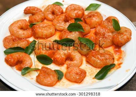 Cooked and peeled shrimps / prawns with green curry leaves ready to eat. seafood prepared in coastal cuisine of Kerala India. Main dish served in house boat. crustaceans freshwater shrimp