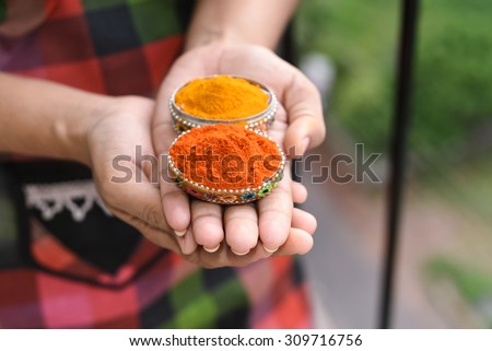 female holding colorful spice mix powder curry, saffron, turmeric, red chilly and yellow turmeric in her hand. Food and cuisine ingredients cooking background Kerala India Asia. Woman holding peppers