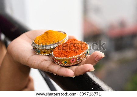 colorful spice mix powder curry, saffron, turmeric, red chilly and yellow turmeric in her hand. Food and cuisine ingredients cooking background Kerala India Asia. Woman holding peppers