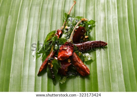 vattal mulaku, Kashmiri/Kashmiry, chili pepper/chile/chilli pepper on banana leaf, genus Capsicum. Dry red chilly pepper, curry leaves used as seasoning  sambar, chutney, curry. Kerala,Tamil Cusines