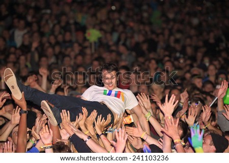 HAMBURG, GERMANY - AUGUST 15, 2014: German DJ and producer ALLE FARBEN doing a stage dive at MS Dockville Festival on August 15, 2014 in Hamburg.
