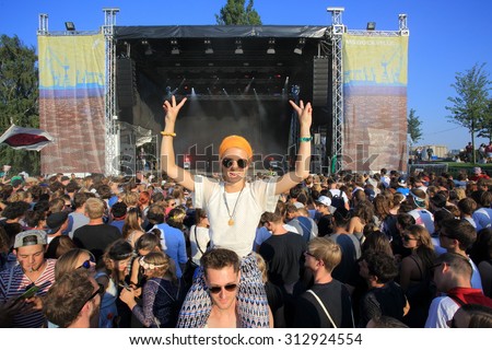HAMBURG, GERMANY - AUGUST 23, 2015: A girl sitting on the shoulder of a guy enjoying the DJ-Set of German DJ and producer ALLE FARBEN at MS Dockville Festival on August 23, 2015 in Hamburg.