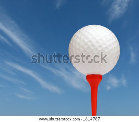 Golf ball on red tee with sky background
