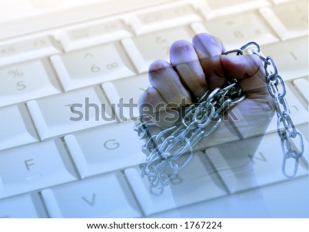 Chained hand overlaying computer keyboard.