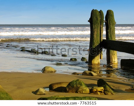 Landscape showing weathered sea defences on beach