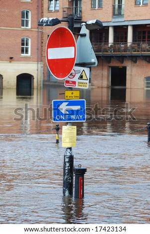 Traffic signs on bank of flooded River Ouse, York.