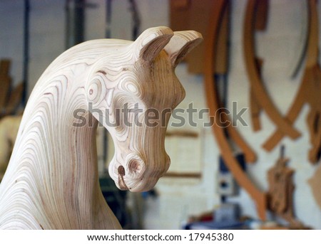 Carved wooden rocking horse head in work shop
