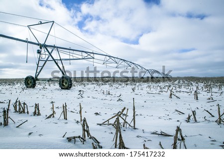Glazed Farm Field with Irrigation Equipment After Winter Ice Storm, Snow and Frozen Rain