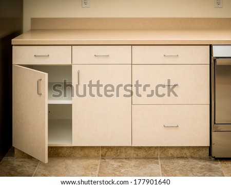 Empty tan kitchen counter and cabinet minimalist style with cabinet door open empty inside