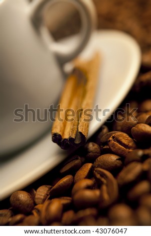cup of coffee and roasted beans with cinnamon
