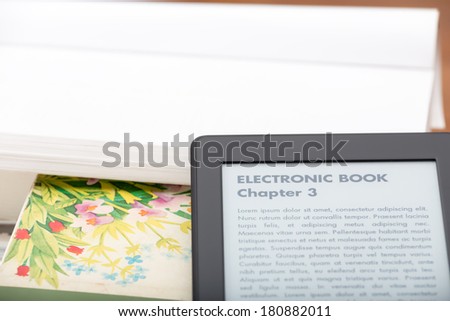 E-book reader with a nice copy space above done with a white paper of a traditional book. The text on the ebook reader is an 