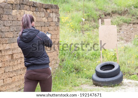 Civilian girl is practicing with her 9mm gun in a shooting range for improving her self-defense technique with gun through tactical dynamic shooting