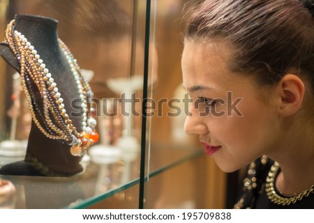 Young woman looking on the jewelry shop window