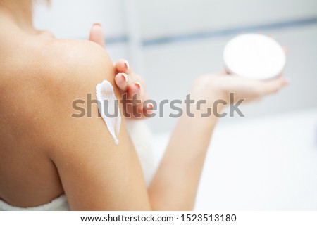 Skin care. Woman use skin care products at home in light bathroom ストックフォト © 