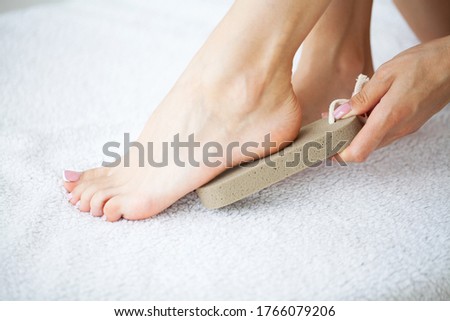 Woman cleans the heel of the foot with pumice 商業照片 © 
