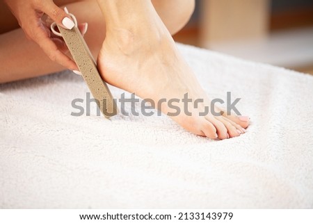 Woman cleans the heel of the foot with pumice at home Stock fotó © 