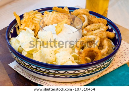 Snack plate. Cheese sauce with ships and roasted calamari rings.