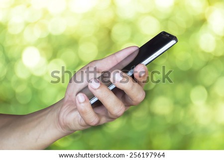 Man hold mobile smart phone green background