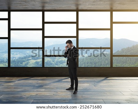 Businessman thinking in modern empty interior