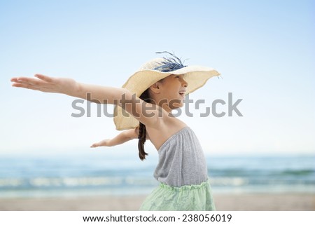 Little girl with arms wide open at beach