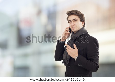 Young businessman talking mobile phone on street