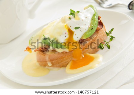 Breakfast. Poached egg with hollandaise sauce, bacon and avocado.