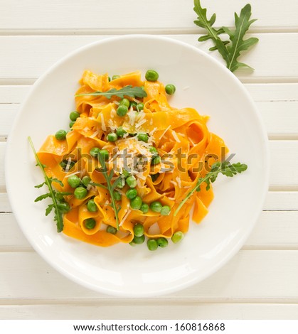 Pumpkin pasta with peas and sun-dried tomatoes.
