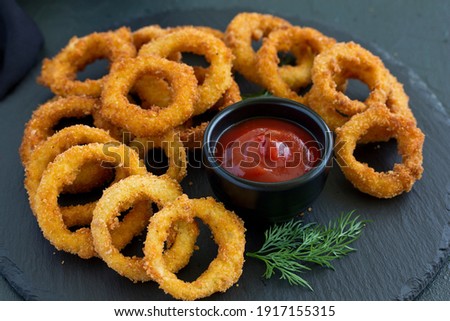 Homemade crunchy fried onion rings with tomato sauce