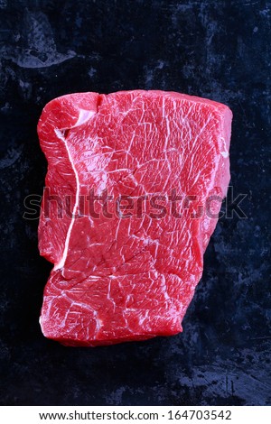 Cut of raw beef on a black background
