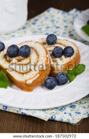 Sliced Sweet Biscuit Roll Cake with fresh berries and a cup of tea.