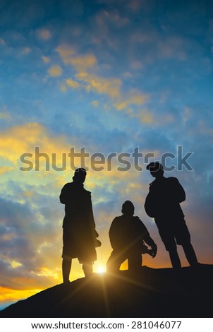 Silhouette of photographers on a hill against the beautiful sunset sky.