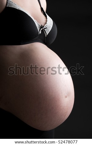 Beautiful Low Key Shot of a Pregnant Woman\'s Bump