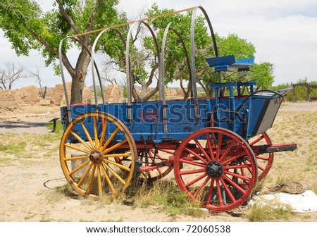 a historic blue, yellow and red covered wagon