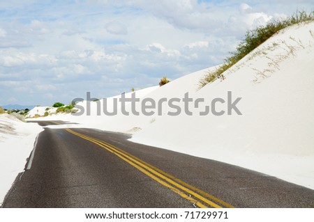 a road and approaching white sand