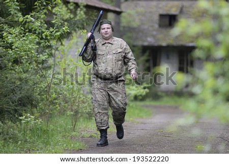 ZASLAWYE, BELARUS - MAY 17: Player walk with gun on during Laser Tag IT-CUP tournament at abandoned summer camp on May 17, 2014 in Zaslawye, Belarus.