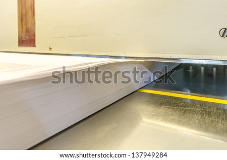 Lower view of a modern paper guillotine with touch screen used in commercial printing industry (industrial knife cutter)