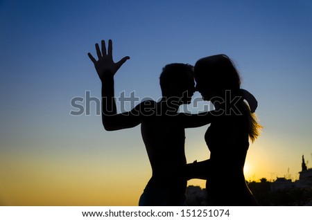 romantic couple silhouette profiles at sunset express love touching noses. Backlit emotion showing 
